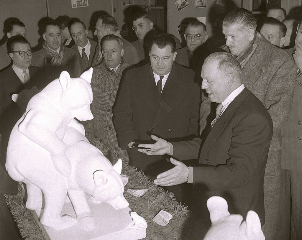 1956 : André GUILLEMIN expliquant une sculpture à M. NORMAND, Sous-Préfet et Armand CHOUFFET, Maire.